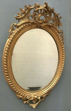 Miroir ovale a fronton en bois et stuc doré Glace ovale biseautée Napoléon III