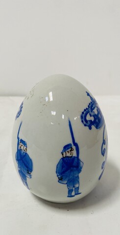 œuf en porcelaine polychrome à décor bleu royal sur fond blanc . XX siècle .