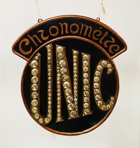 enseigne publicitaire de la marque UNIC en stuc patiné et miroir . XX siècle .