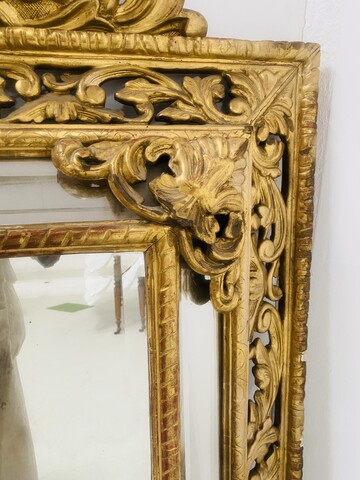 miroir bois doré à pare clause en bois stuqué doré miroir biseauté . XIX siècle.