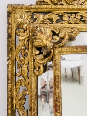 miroir bois doré à pare clause en bois stuqué doré miroir biseauté . XIX siècle.