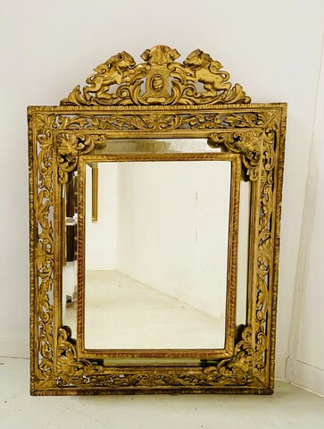 miroir bois doré à pare clause en bois stuqué doré miroir biseauté . XIX siècle.