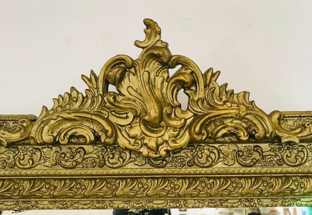 miroir en stuc à coquille patine bronze décor floral fond en sapin . XX siècle .